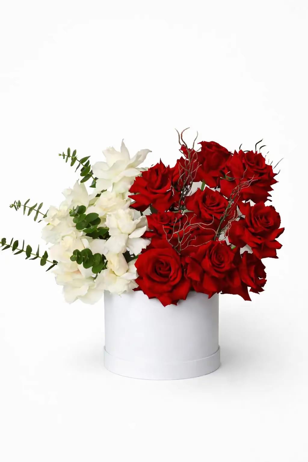 Bouquet of red and white flowers in a white box on a white background